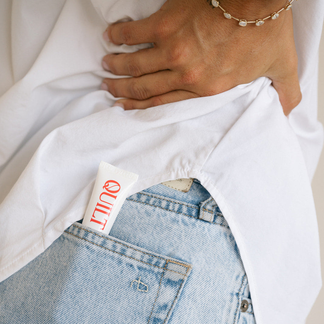 Close-up of a person wearing a white shirt and blue jeans with a visible Levi's tag.